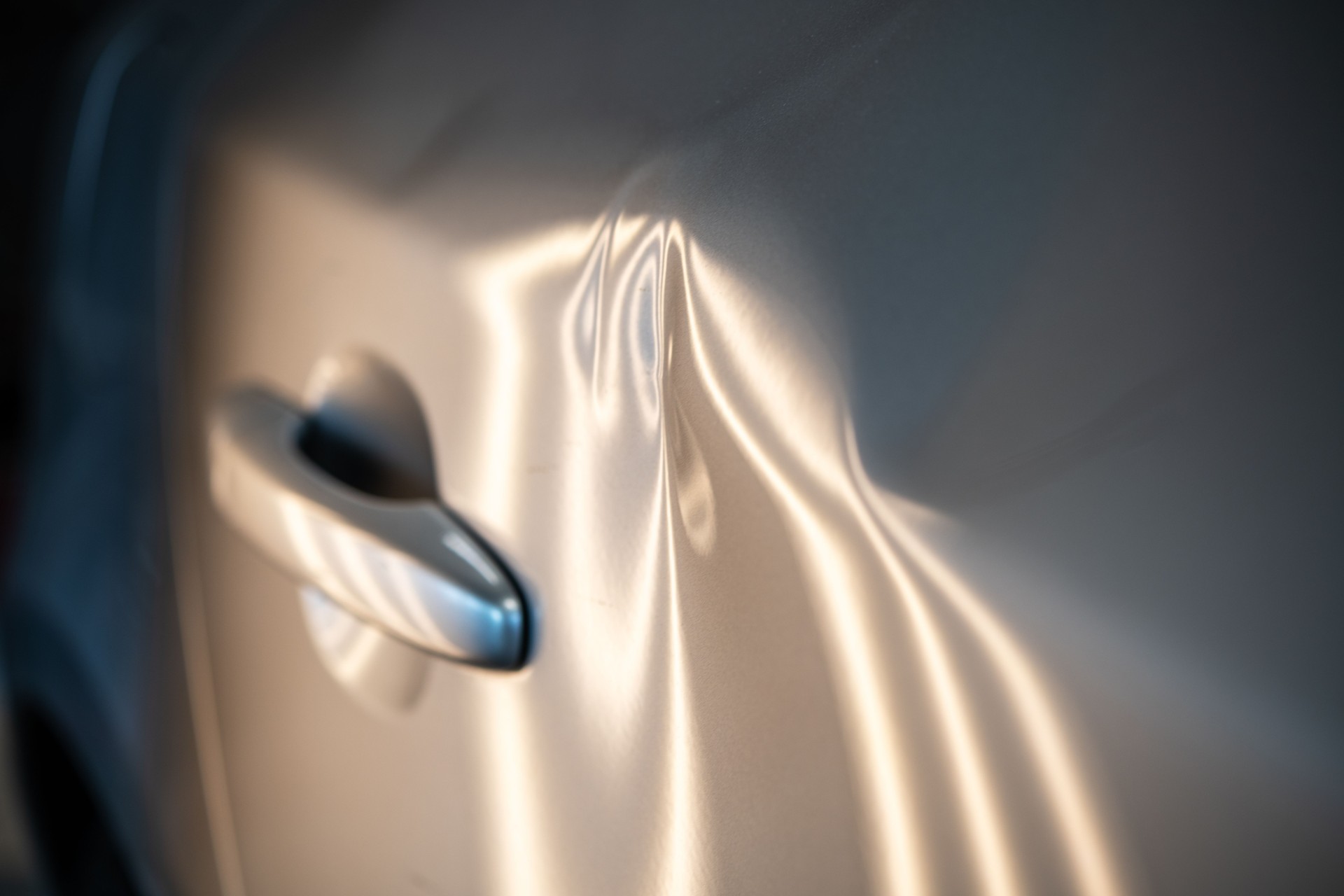 Car Door Dents with Light Reflections Highlighting Damage, Insurance Claims and Repair Options Overview